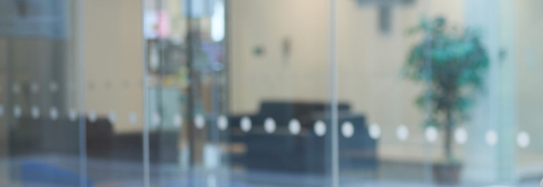 Blurred image of PPF Office, glass windows, sofa, and tree