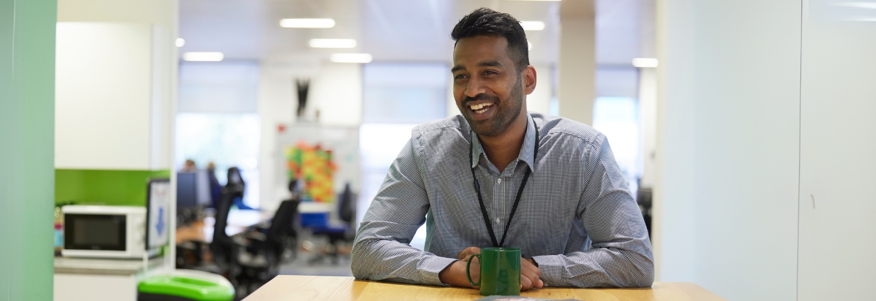 A PPF employee smiling, sitting at a desk in the office
