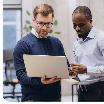 Two people looking at a laptop in an office
